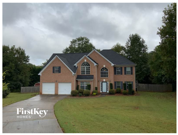 A brick house with a black roof and a white garage door.
