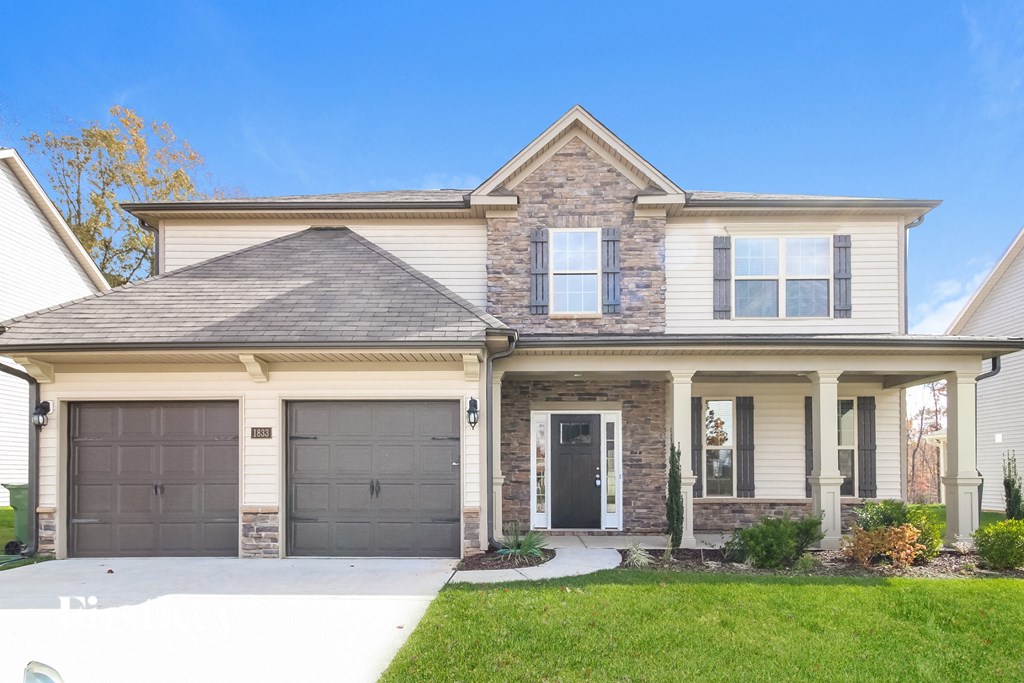 a house with two garage doors and a driveway