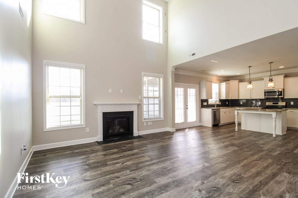 the living room and kitchen of a new home with a fireplace