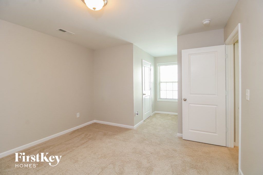 a bedroom with a white door and a carpeted floor