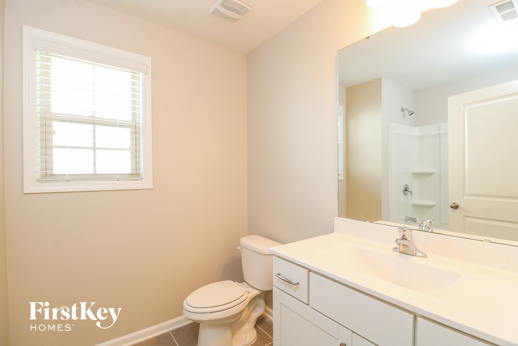 a bathroom with a toilet and a sink and a mirror