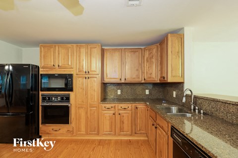 a kitchen with wooden cabinets and granite counter tops