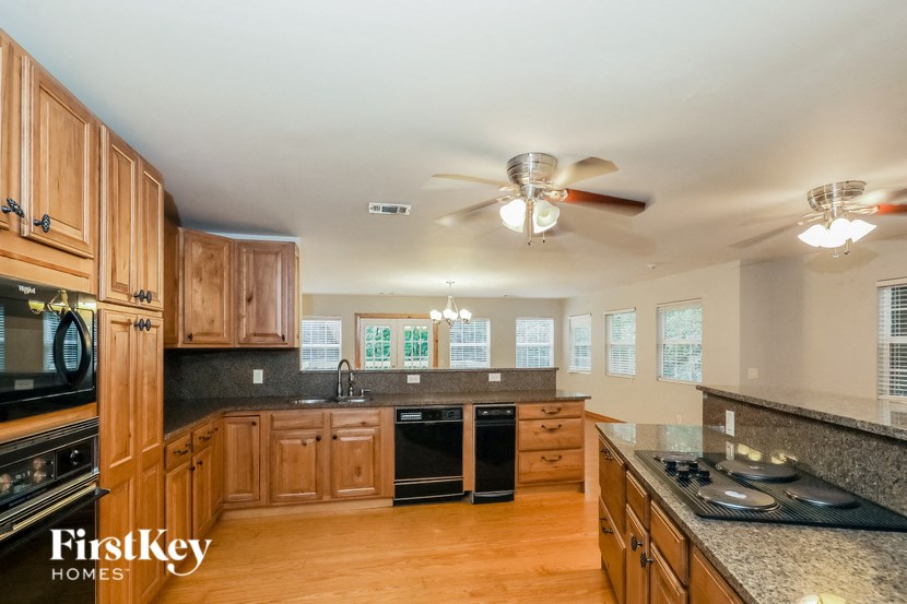 a large kitchen with wooden cabinets and a ceiling fan