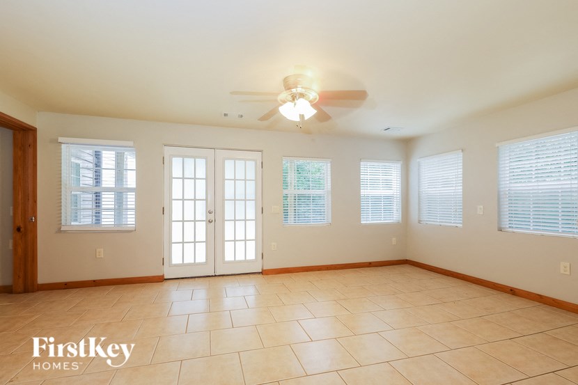 a large living room with a ceiling fan and windows