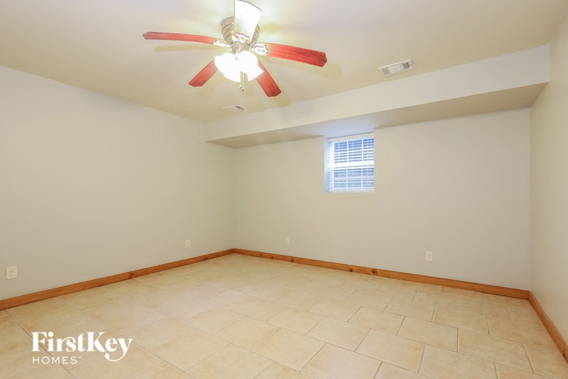 a empty living room with a ceiling fan