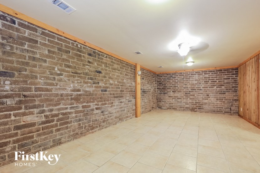 a brick wall in a room with a tile floor
