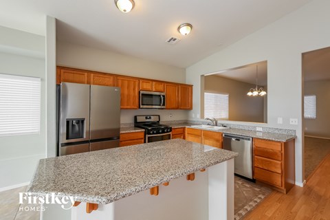 A kitchen with a granite countertop and wooden cabinets.