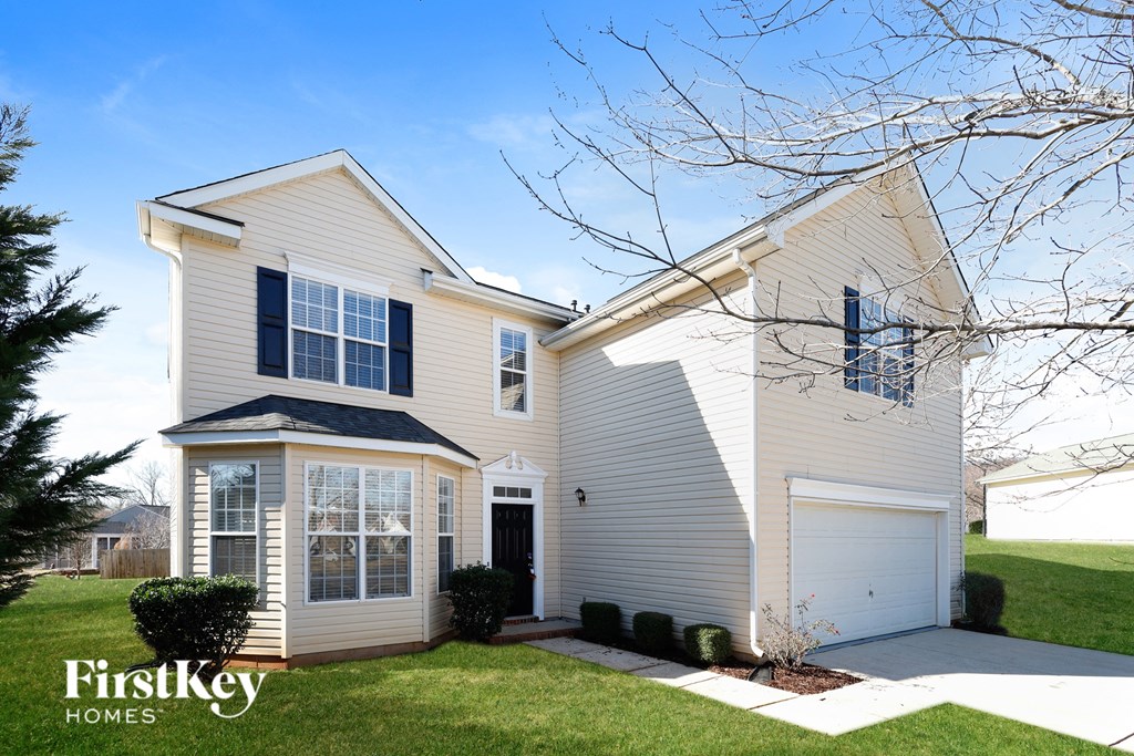 a white house with black shutters and a white driveway