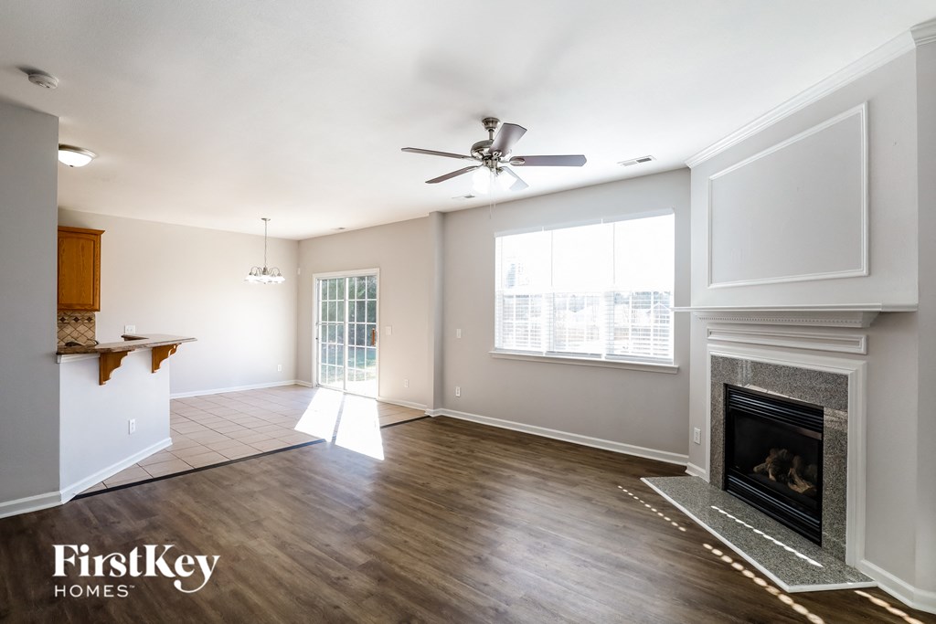 a living room with a fireplace and a ceiling fan