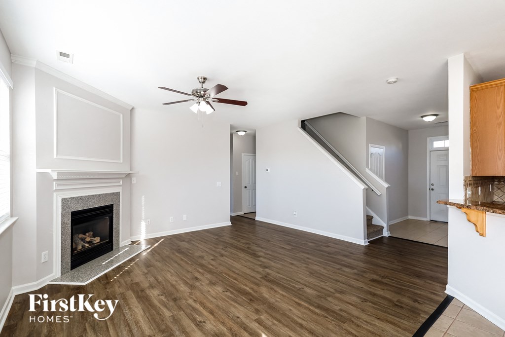 a living room with a fireplace and a ceiling fan