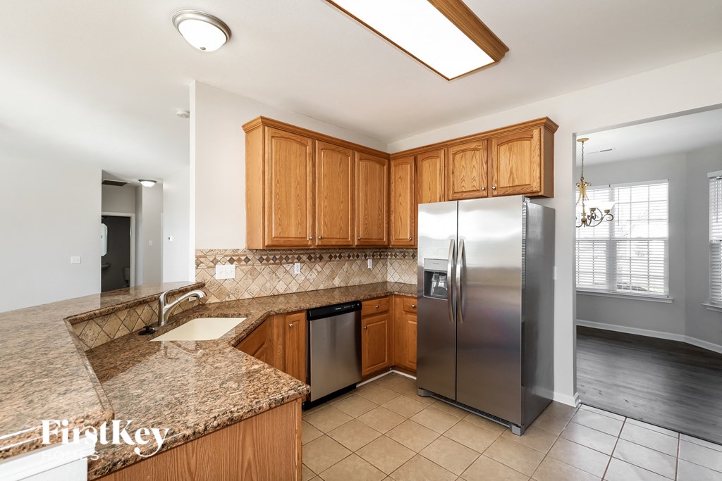 a kitchen with wooden cabinets and a stainless steel refrigerator
