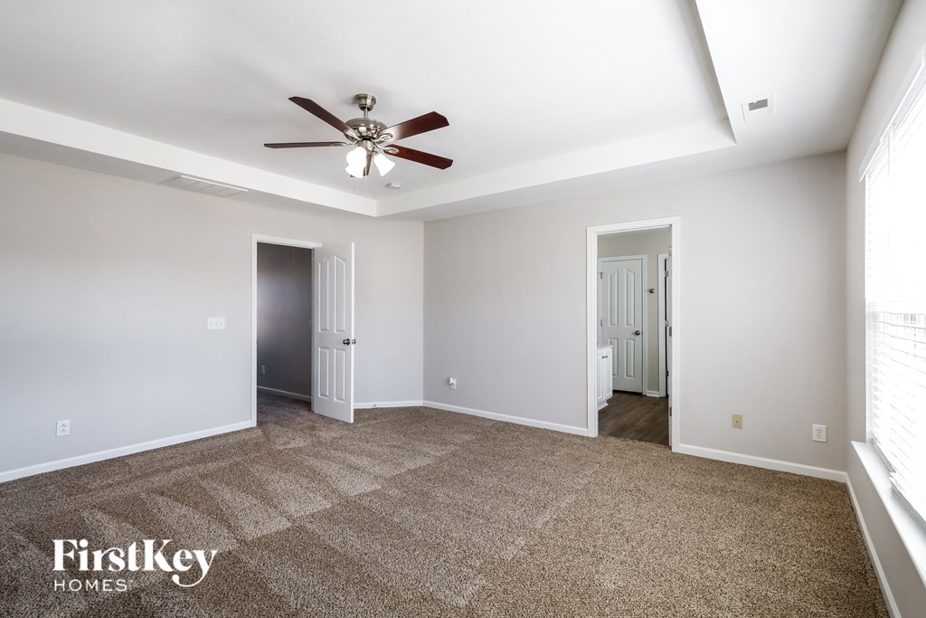 a living room with carpet and a ceiling fan