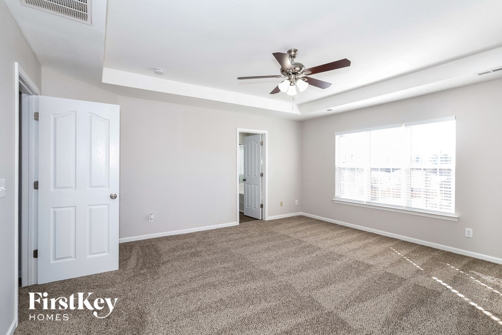 a living room with carpet and a ceiling fan