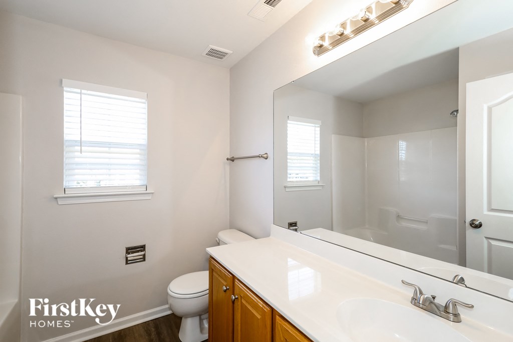a bathroom with a large mirror and a sink and a toilet