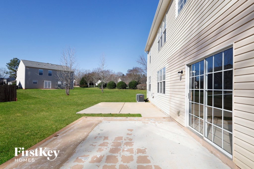 a side view of the side of a house with a driveway and a garage door