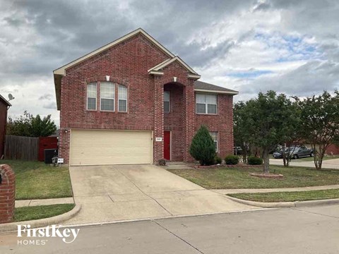 the front of a brick house with a white garage door