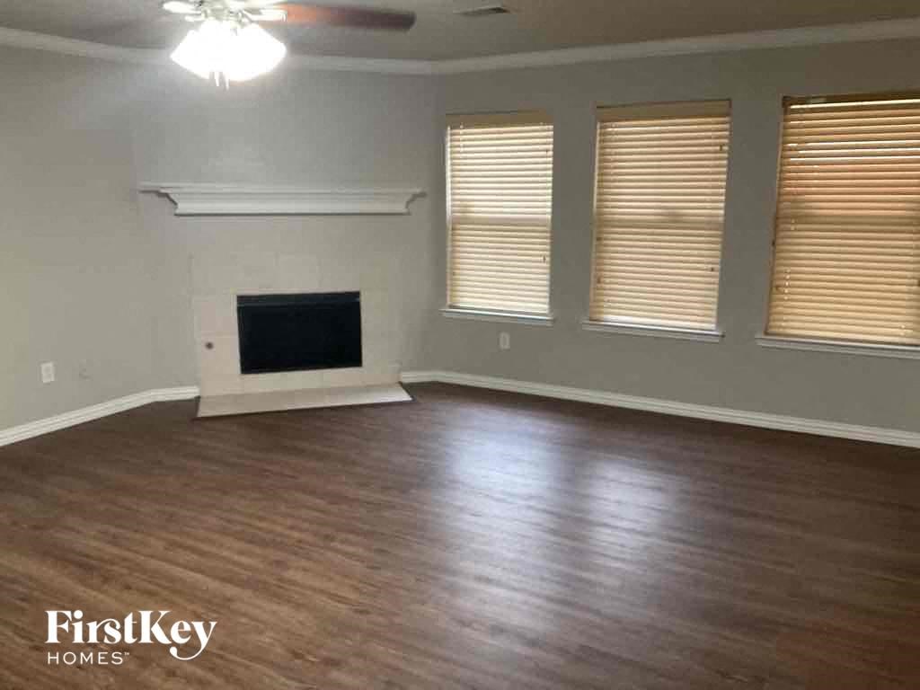 an empty living room with wood floors and a fireplace