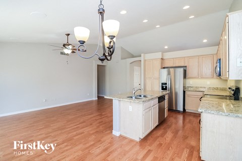 A kitchen with wooden floors and a chandelier.