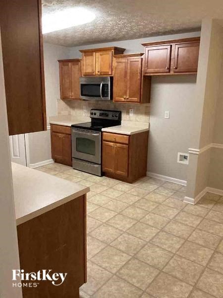 A kitchen with wooden cabinets and a tiled floor.