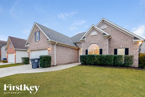 A house with a garage and a driveway in front of it.