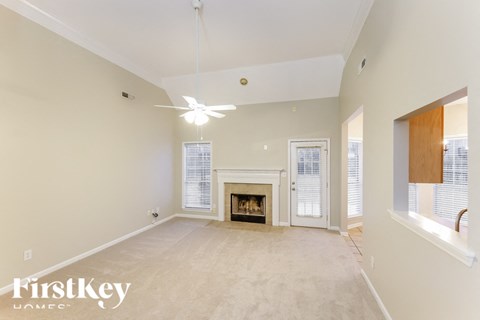 A spacious living room with a fireplace and sliding glass doors.