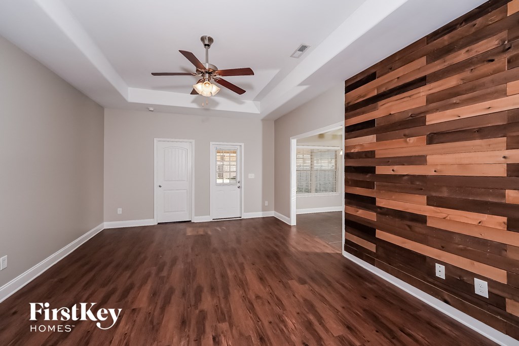 a living room with a wooden wall and a ceiling fan