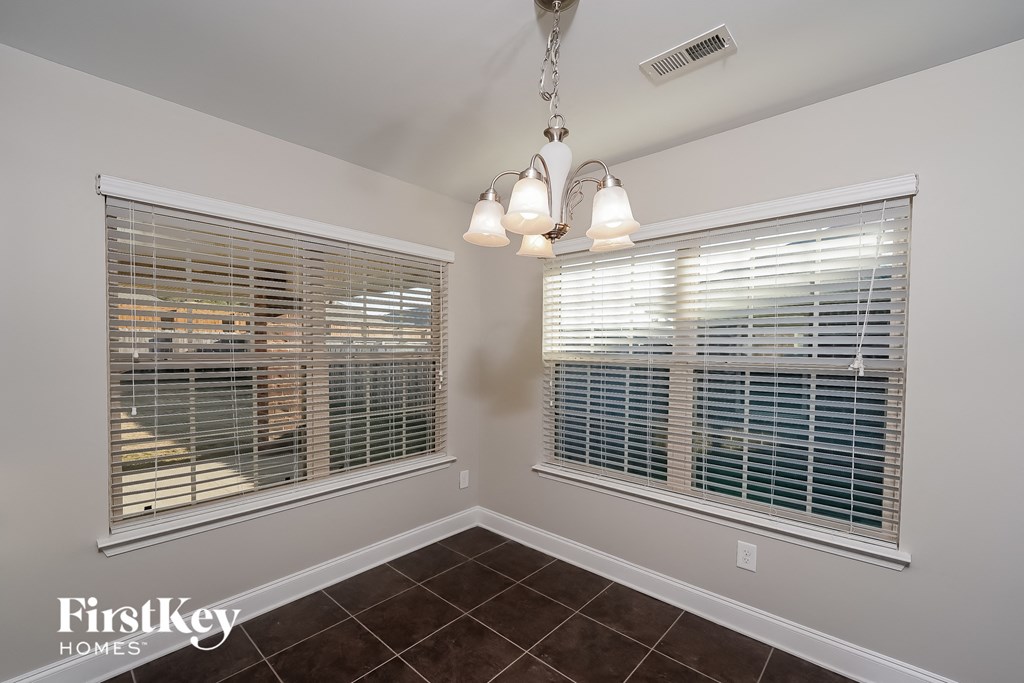 the living room of a home with two windows and a chandelier
