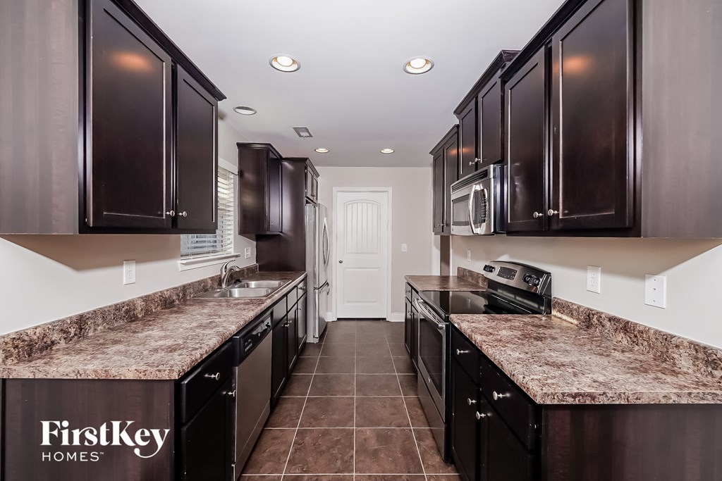 a kitchen with dark wood cabinets and granite counter tops