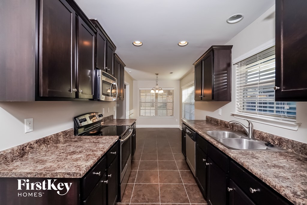 a kitchen with dark wood cabinets and granite counter tops