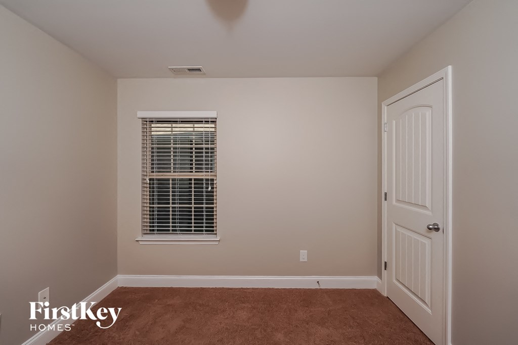 a bedroom with a window and a white door
