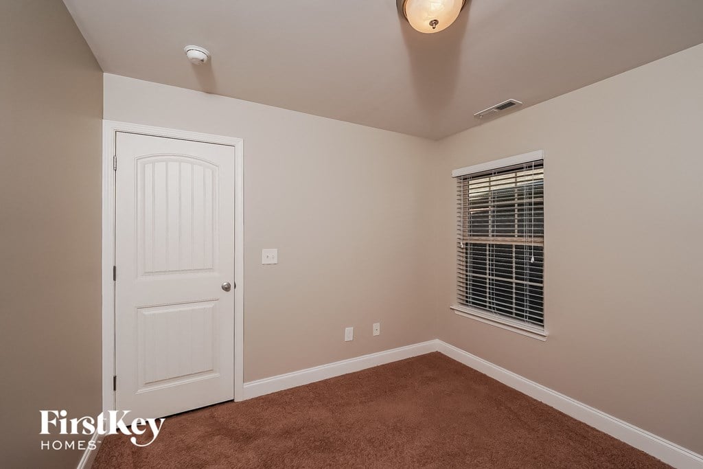 a bedroom with a white door and a window