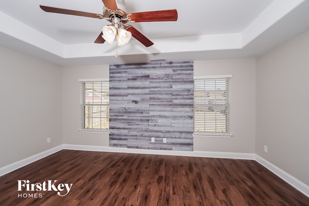 the living room with a wood floor and a ceiling fan
