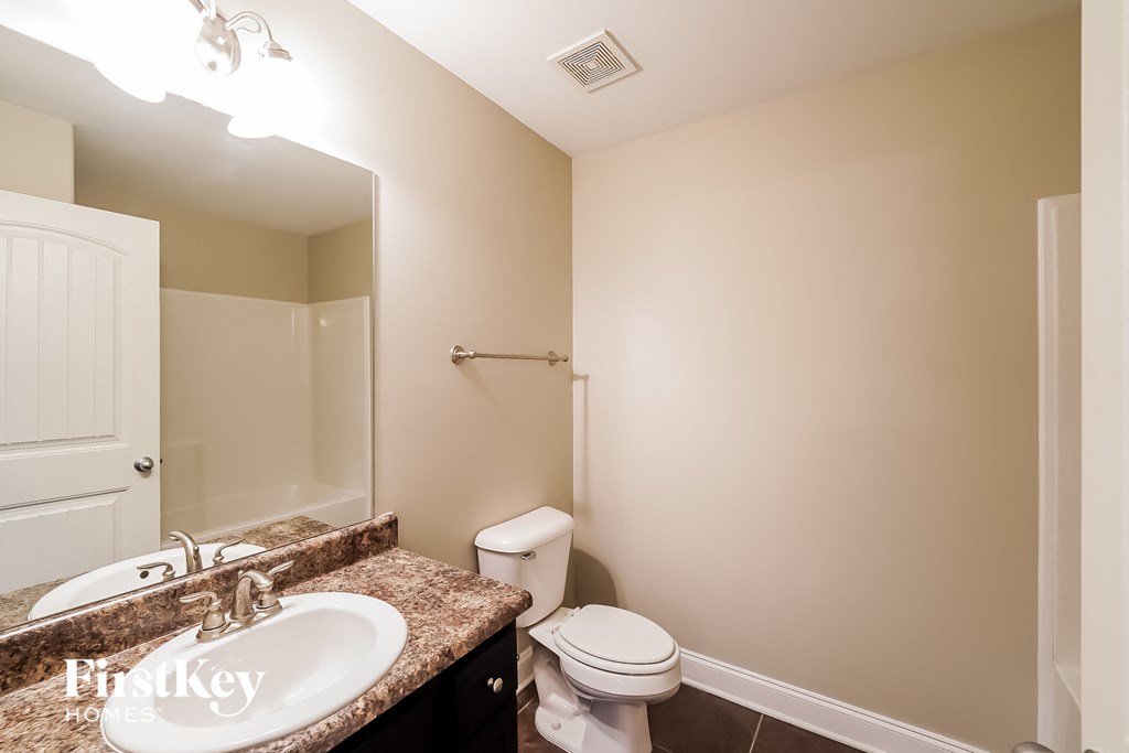 a bathroom with a sink and a toilet and a mirror