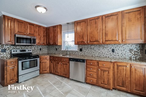 A kitchen with wooden cabinets and a tiled backsplash.