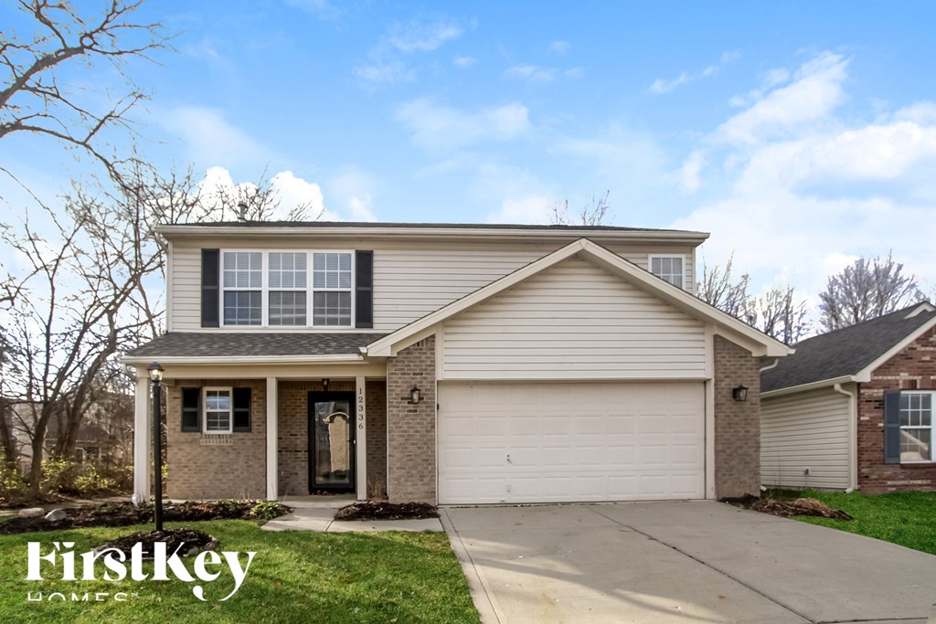 A house with a garage and a driveway is for sale.