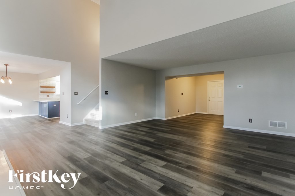 A spacious room with wooden flooring and a white ceiling.