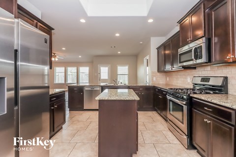 a large kitchen with stainless steel appliances and granite counter tops