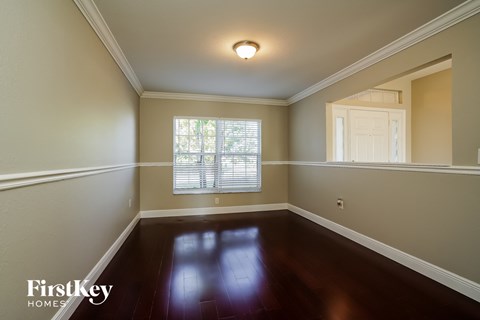 a empty dining room with hardwood floors and a window