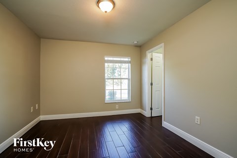 the living room of a house with wooden floors and a window