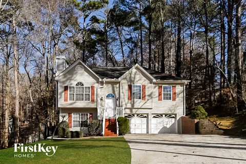 a white house with red shutters and a driveway