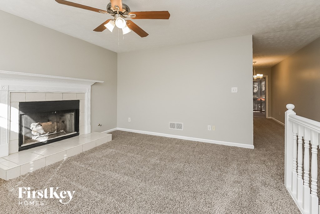 a living room with a fireplace and a ceiling fan