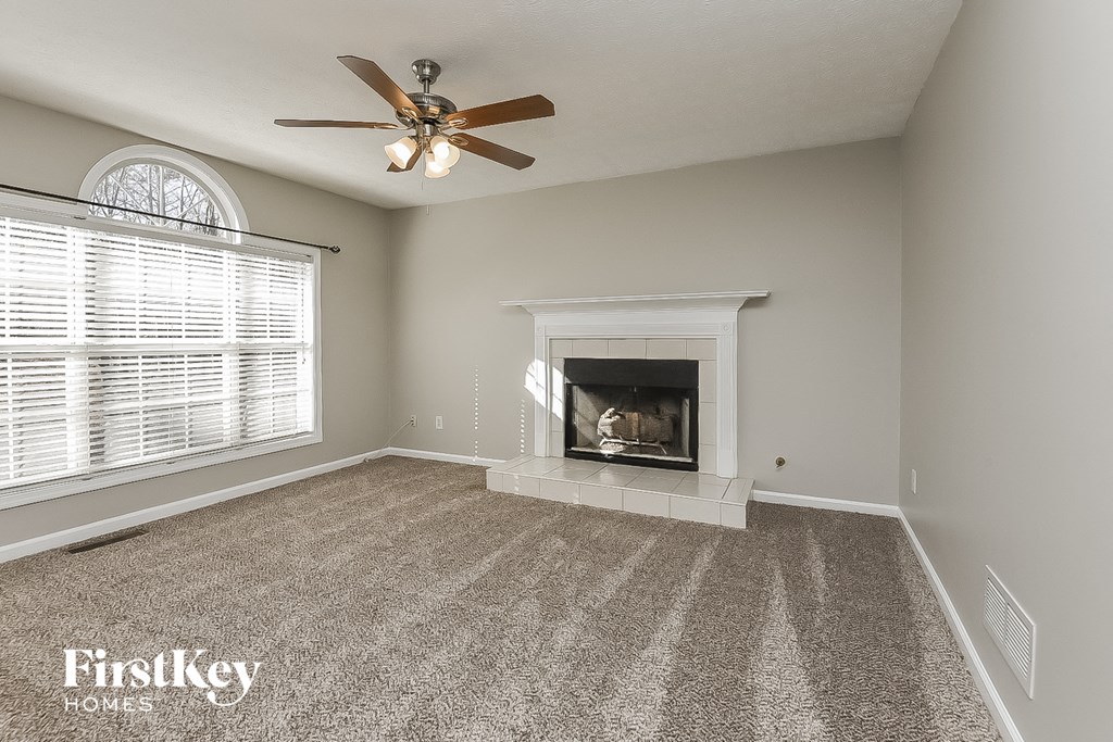 a living room with a fireplace and a ceiling fan