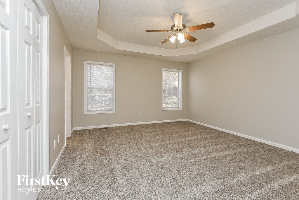 an empty living room with a ceiling fan