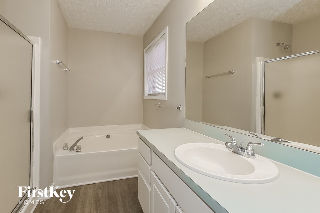 a bathroom with a sink and a tub and a mirror