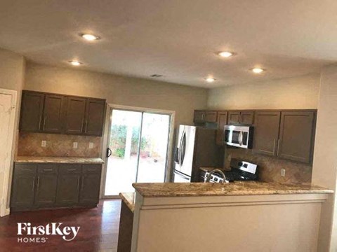 A kitchen with brown cabinets and a granite countertop.