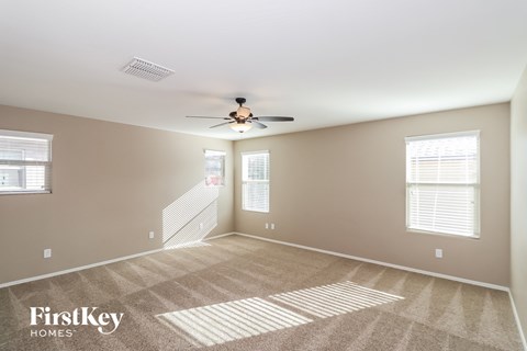 a living room with carpet and a ceiling fan