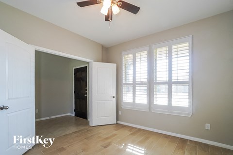 a living room with a ceiling fan and windows