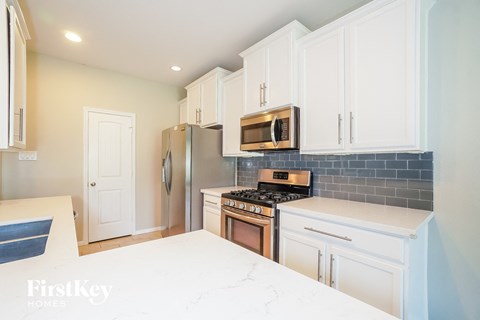 a kitchen with white cabinets and stainless steel appliances