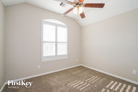 the master bedroom has a ceiling fan and a carpet