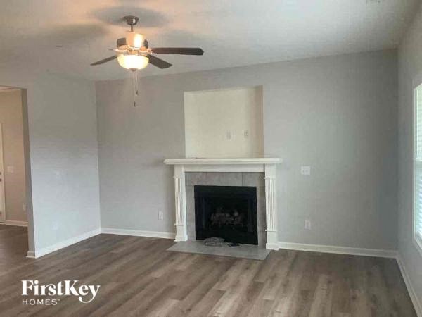 A living room with a fireplace and a ceiling fan.